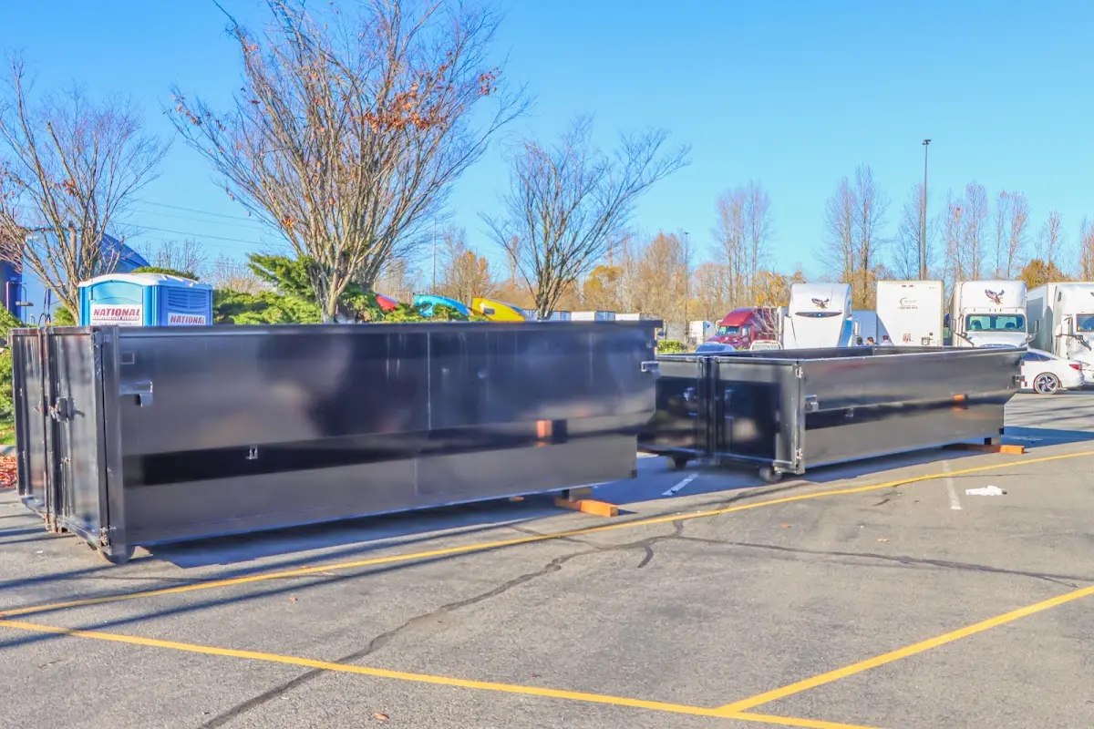 Professional dumpster rental service with roll-off container on residential driveway in Olympia Heights